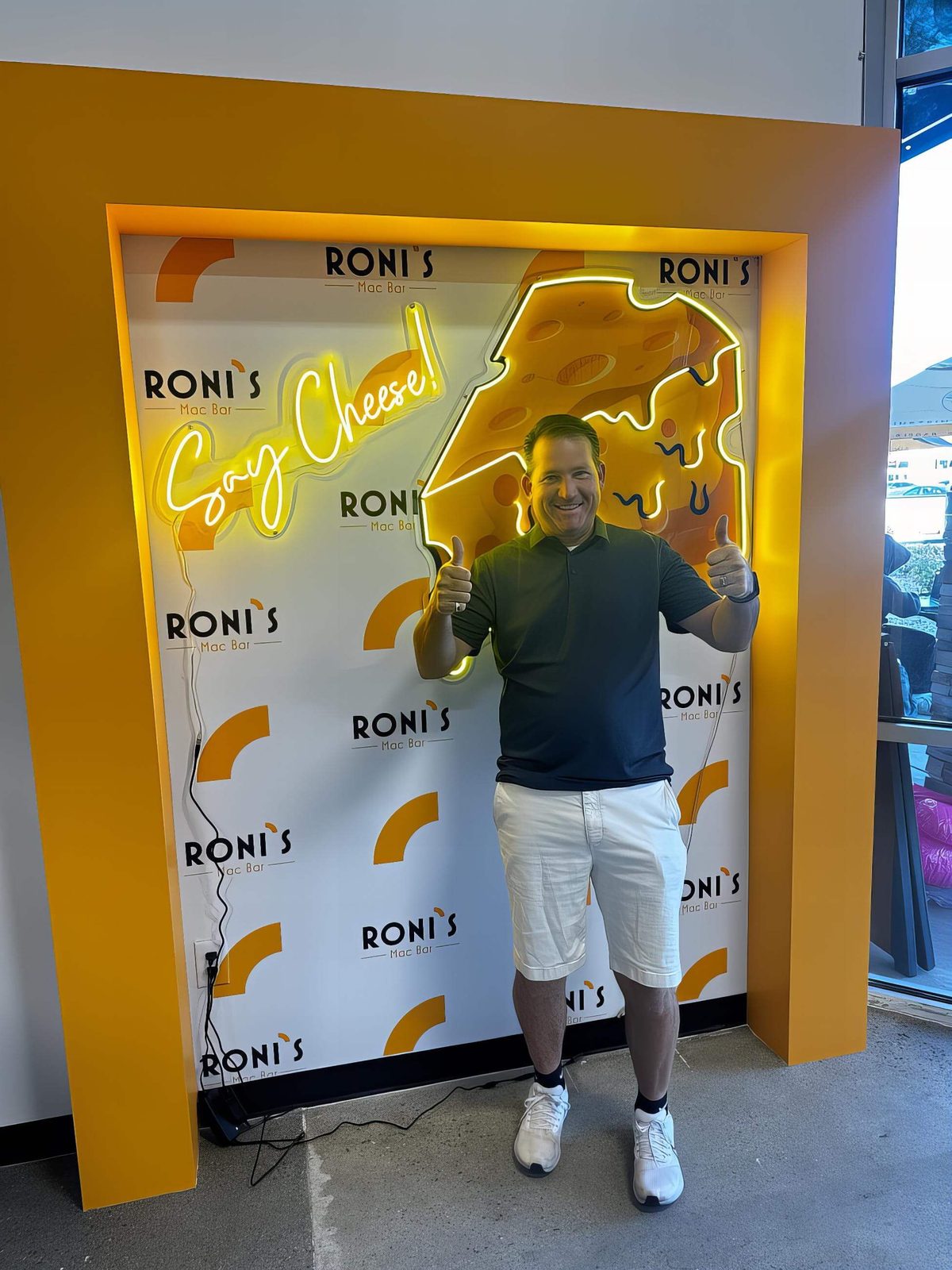 Roni's Say Cheese brand backdrop at a pop-up stand
